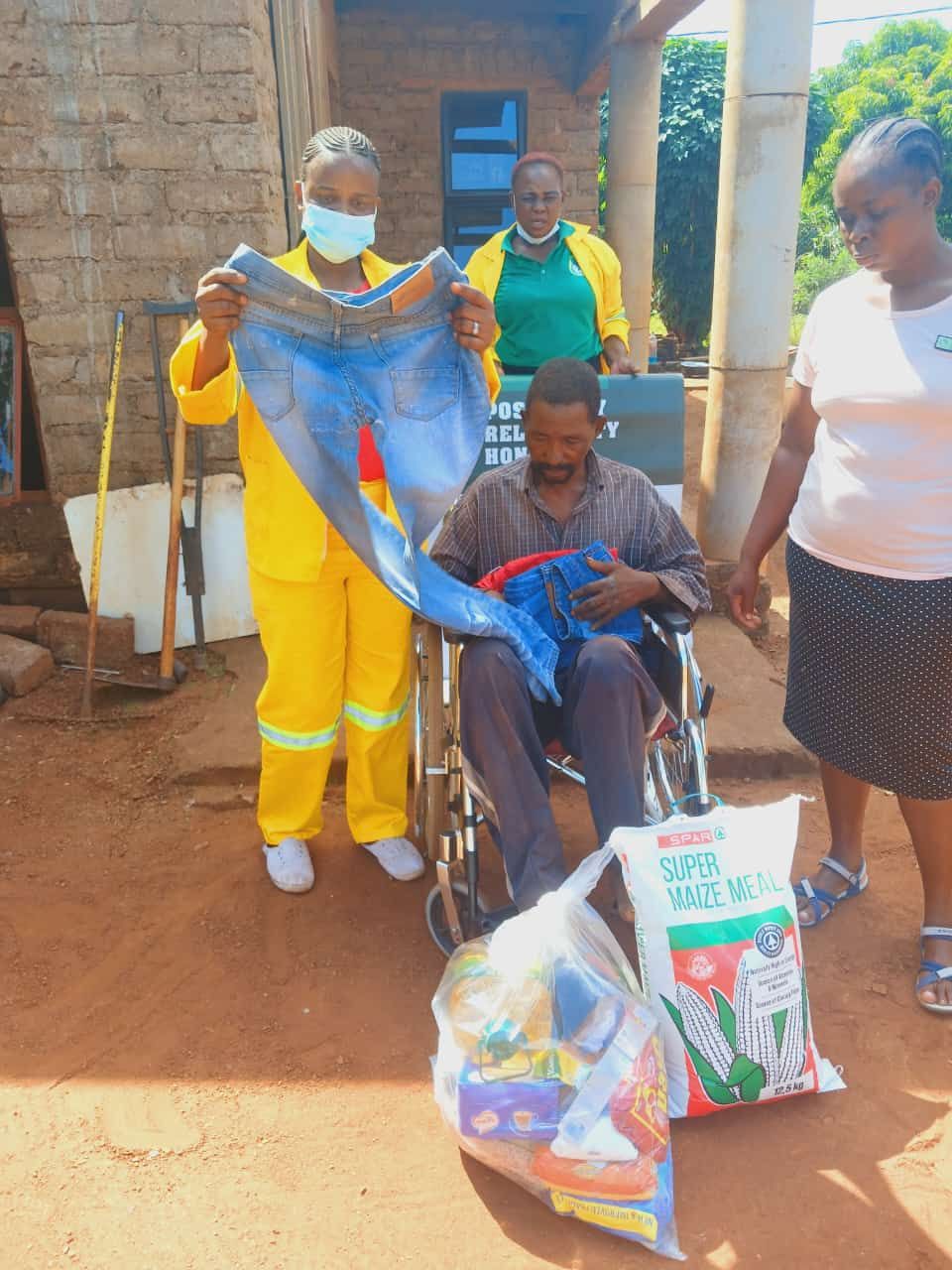 EMISSC supporting a community member with a wheelchair and supplies